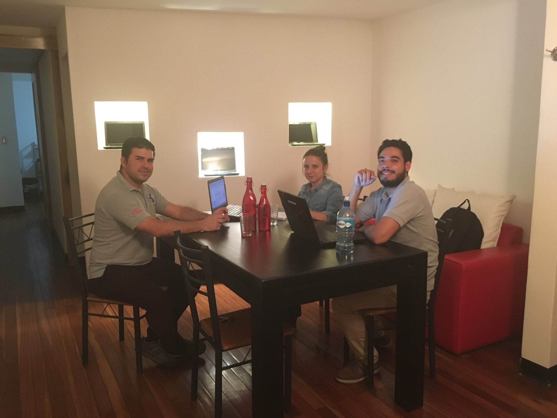 Colaboradores de IT DigiTEC trabajando alrededor de una mesa