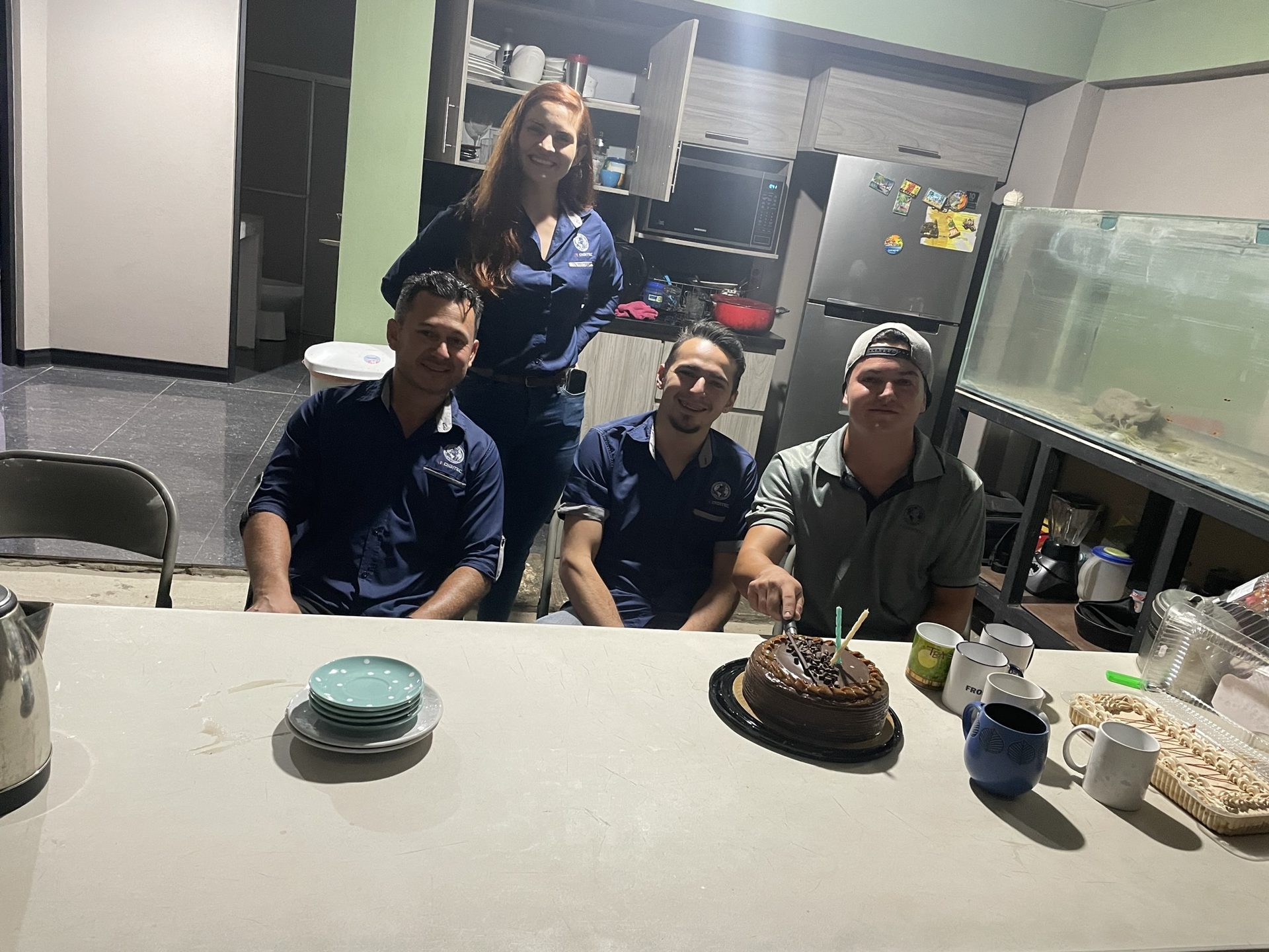 Colaboradores celebrando juntos alrededor de un pastel